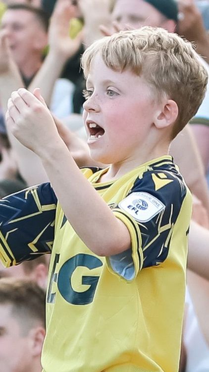 Young fan cheering on Oxford United
